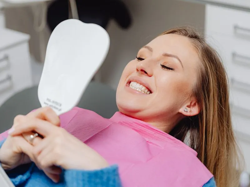 Patient smiling with satisfaction after full-mouth reconstruction