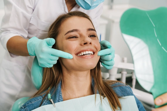 Patient smiling in dental chair with dentist — a positive veneer consultation experience